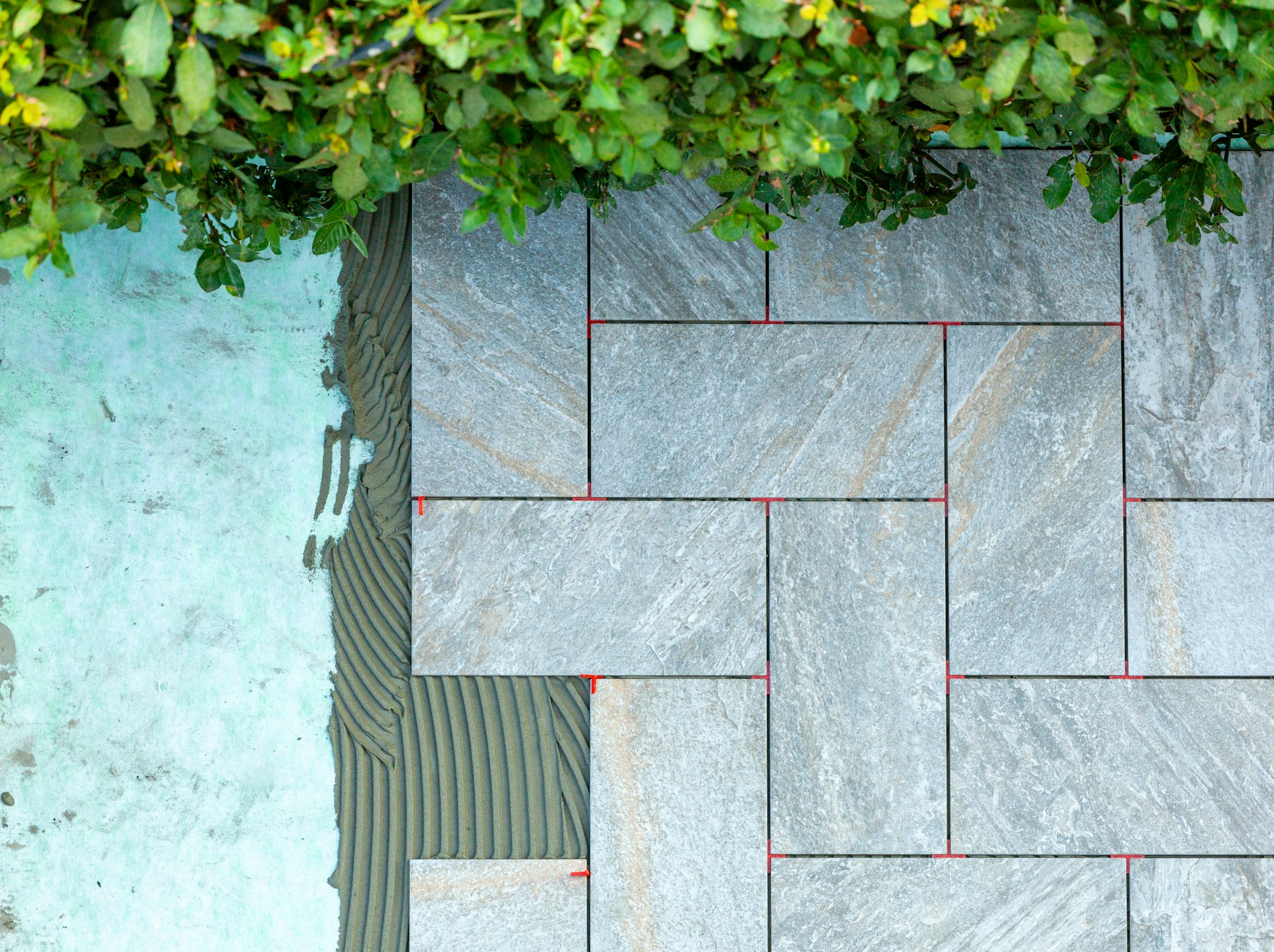Laying outdoor tiles on a sound-absorbing mat.